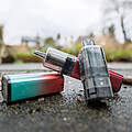 Wiederaufladbare Vapes liegen draußen auf dem Asphalt.