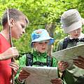 Kinder mit Karte und Rucksack im Wald