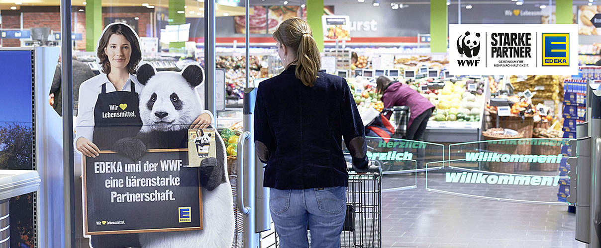 Edeka Eingang mit Kundin und Logo © EDEKA