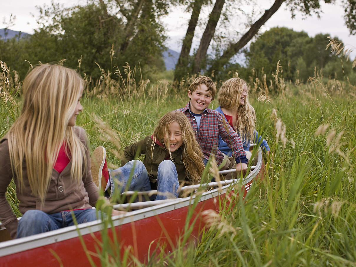 Kinder in einem Boot auf einer Wiese 
