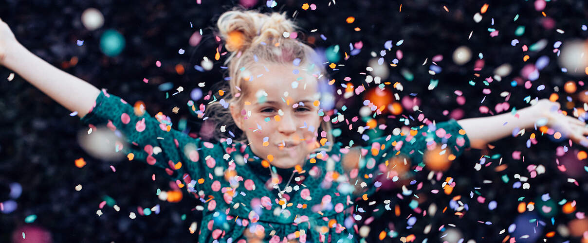 Mädchen wirft Konfetti 