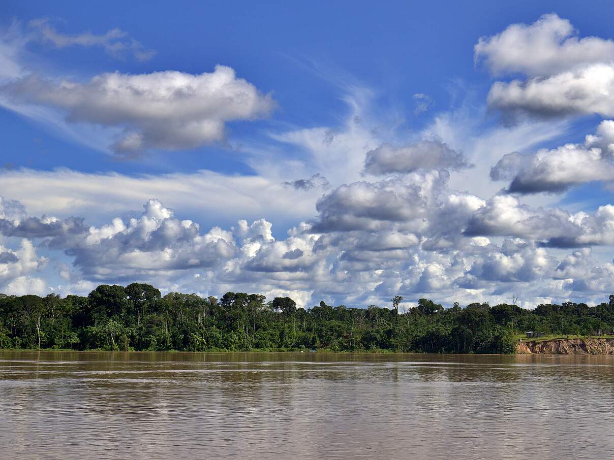Wolkenformation über Fluss mit Wald am Ufer