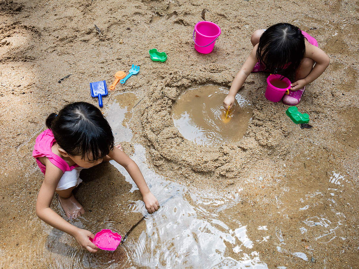 Kinder spielen im Sand mit Wasser © GettyImages Kinder spielen im Sand mit Wasser