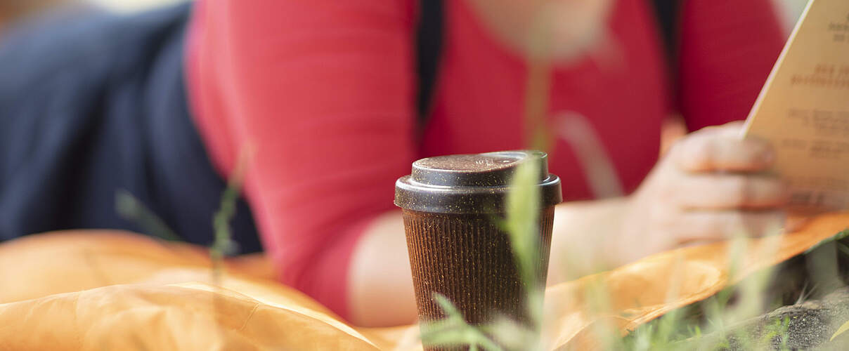 Kaffee im Park in einem Mehrweg-Trinkbecher