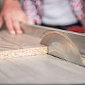 Woman and man using power tools in a carpenter workshop