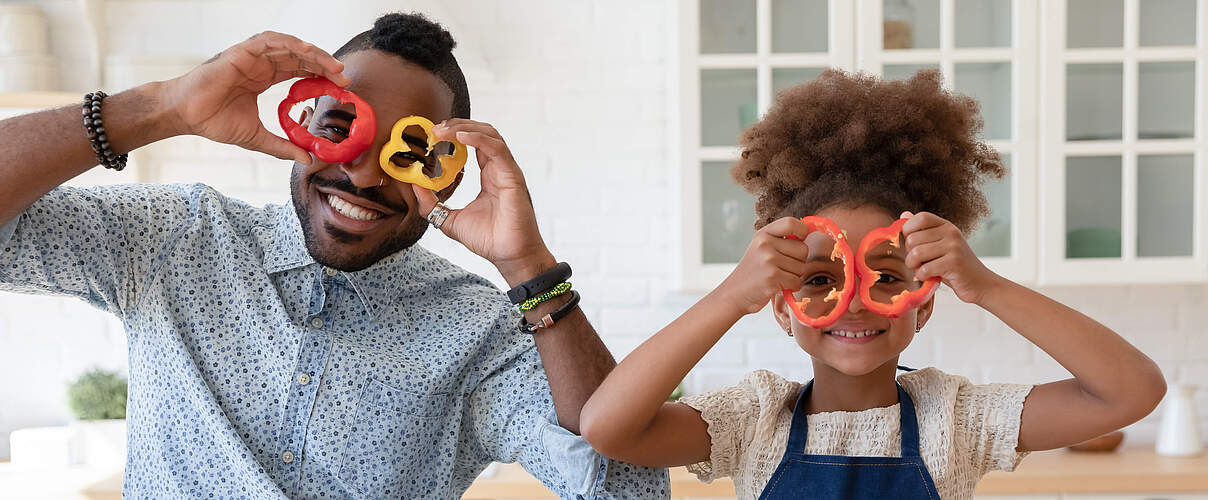 Mann und Kind schneiden Paprika
