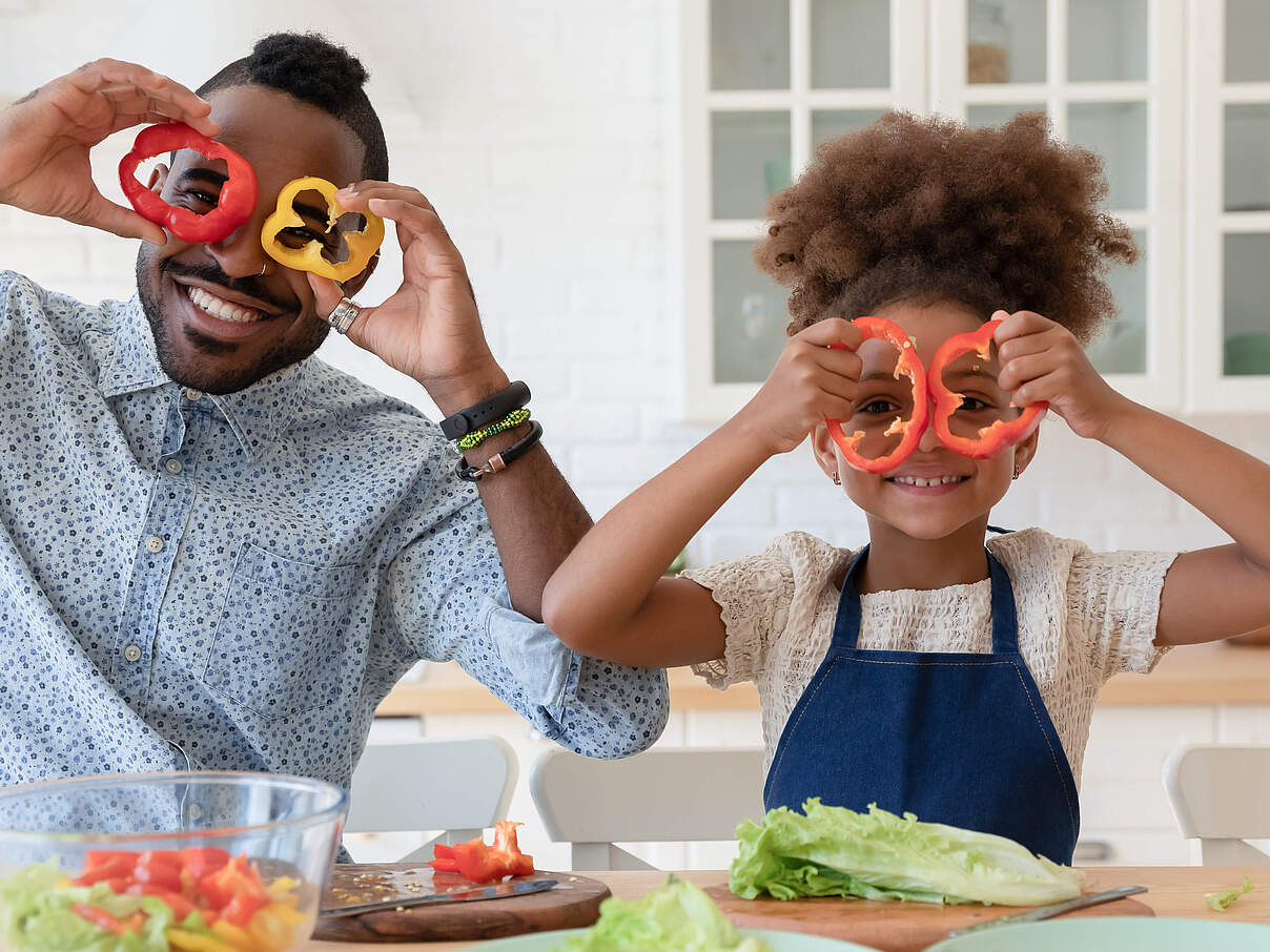 Mann und Kind schneiden Paprika