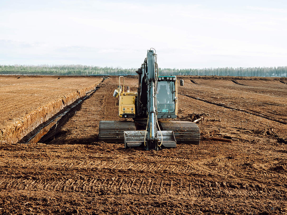Bagger gräbt Entwässerungsgraben in Torfgewinnungsanlage