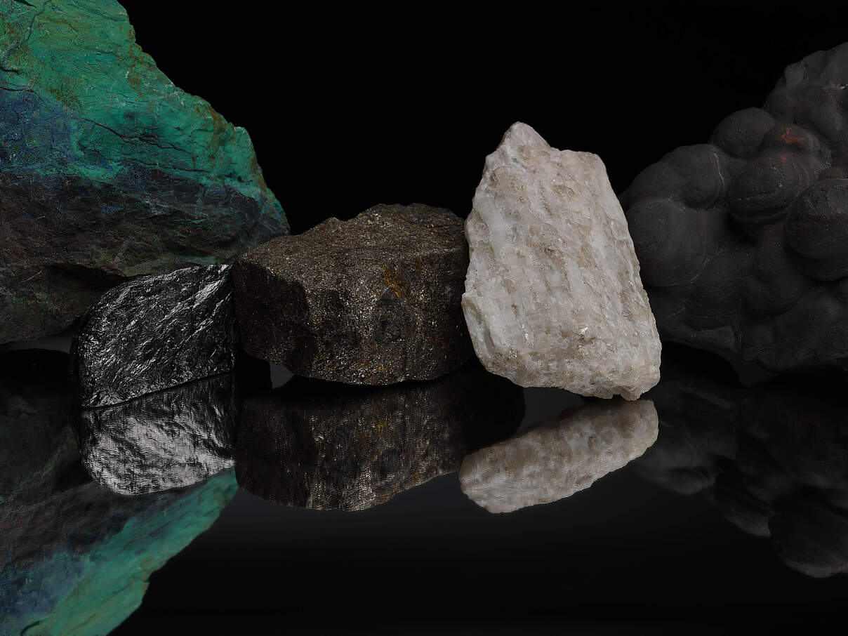 Auf einer spiegelnden Fläche sind Kupfer, Grafit, Nickel, Lithium und Mangan zu sehen.