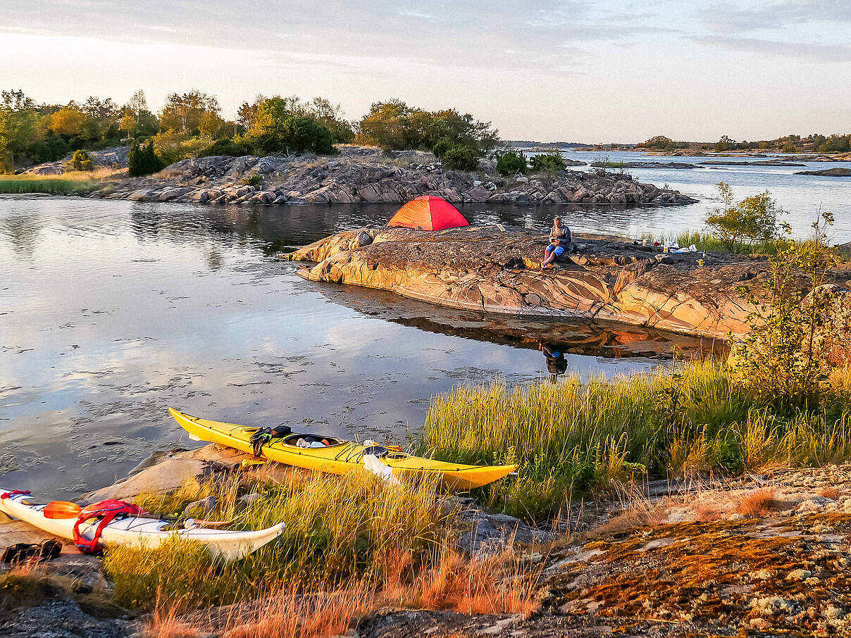 Schöne Landschaftaufnahme an einem Fluss in Schweden mit Kanus und Menschen die die Natur geniessen