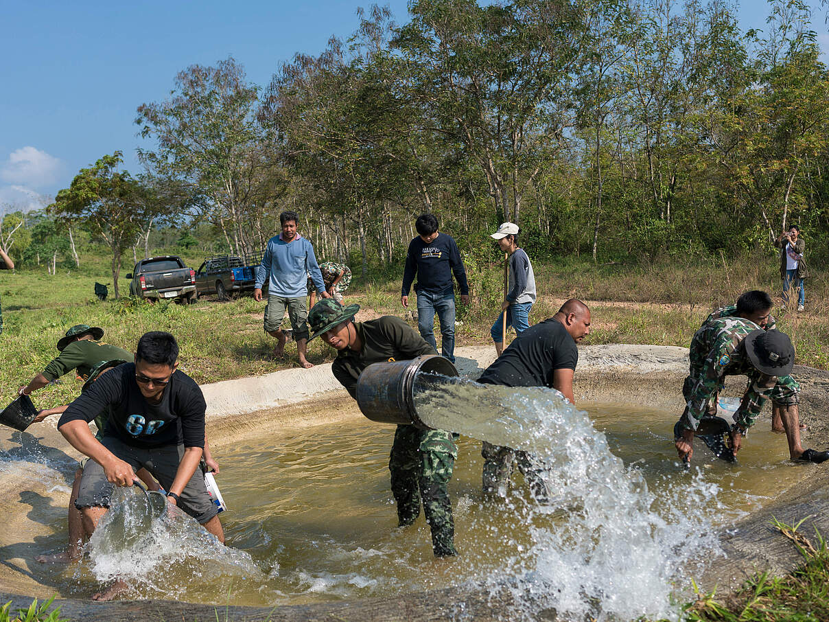 Ranger reinigen ein Wasserloch im Kui Buri Nationalpark in Thailand 