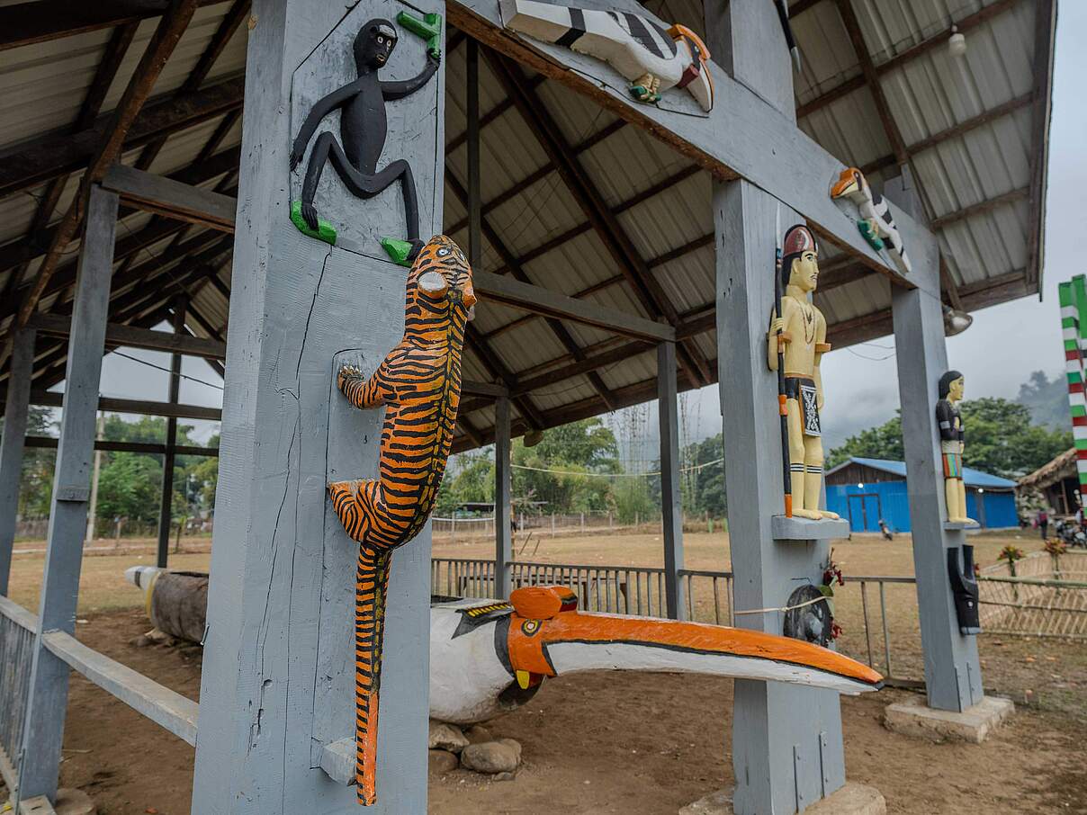 Totempfähle und religiöse Tierstatuen, mittig ein großer, hölzerner Tiger an einem der Pfähle