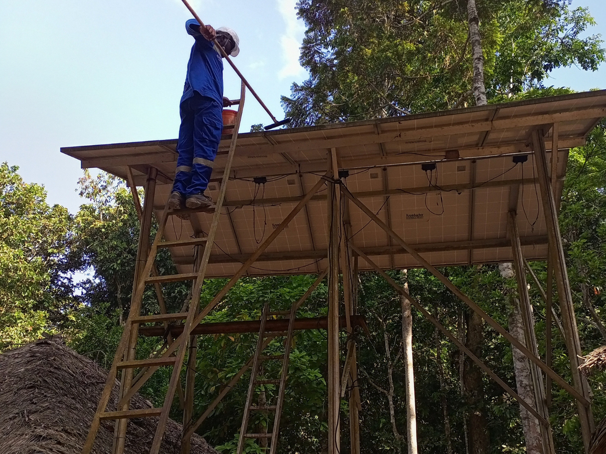 Auf einem Haus wird eine Solarpaneel befestigt.