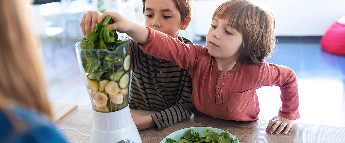 Kinder mixen einen Smoothie