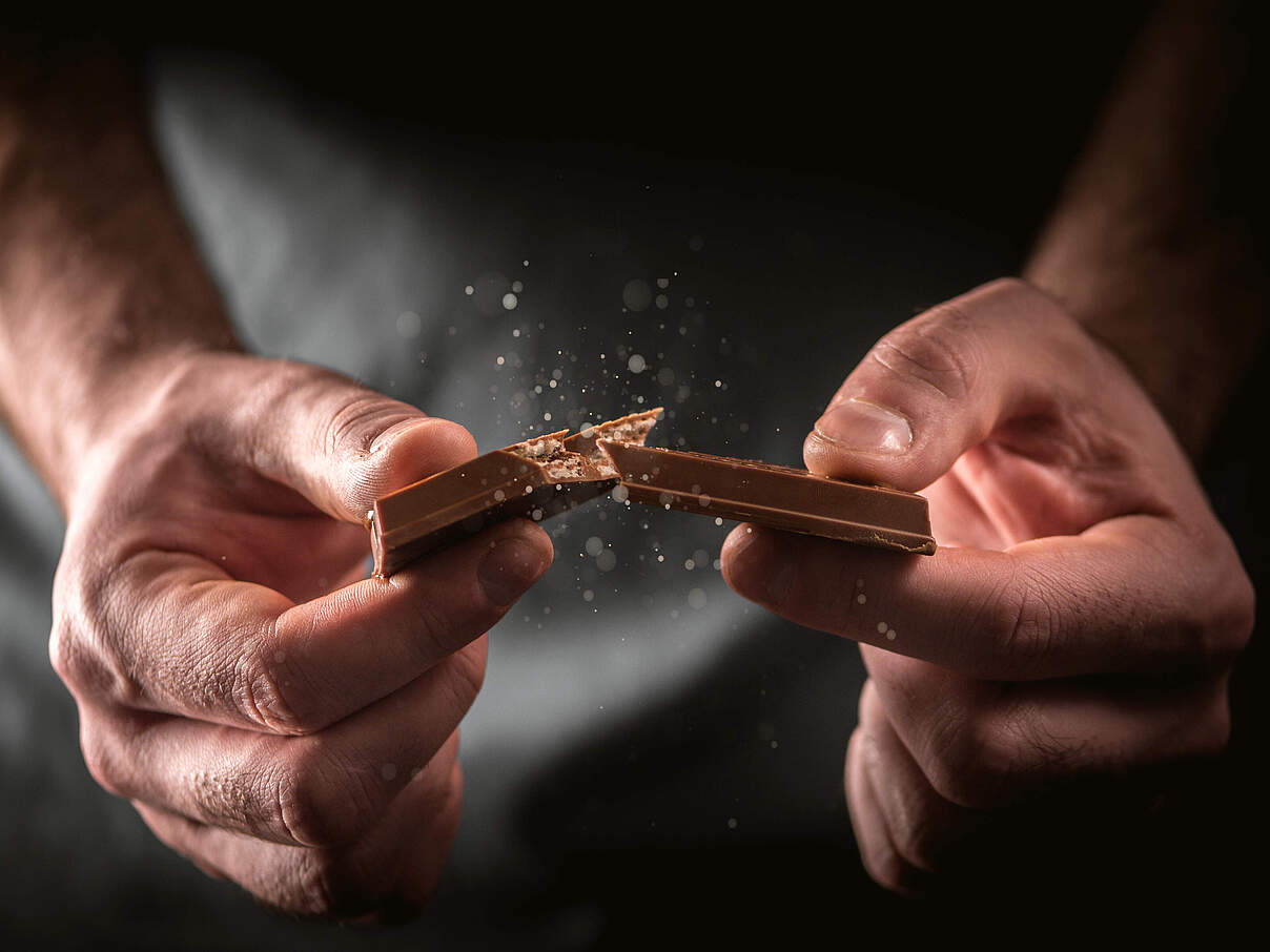 Mann bricht Schokolade