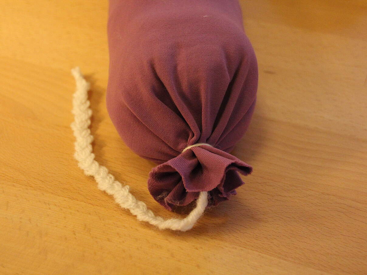 Verknotetes Ende eines Zugluftstoppers aus Strumpfhosen