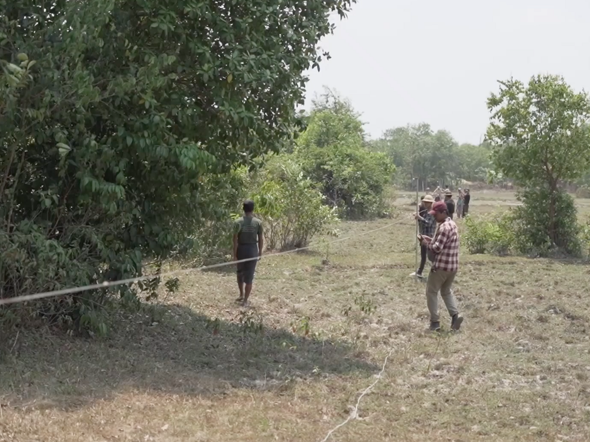Die Dorfbewohner:innen bereiten den Zaun zur Abwehr der Elefanten vor.