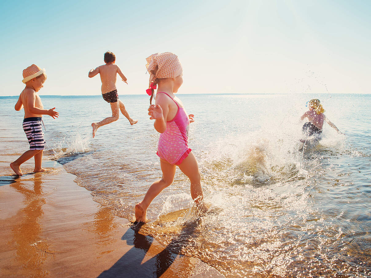 Kinder rennen am Strand ins Wasser © GettyImages Kinder rennen am Strand ins Wasser © GettyImages