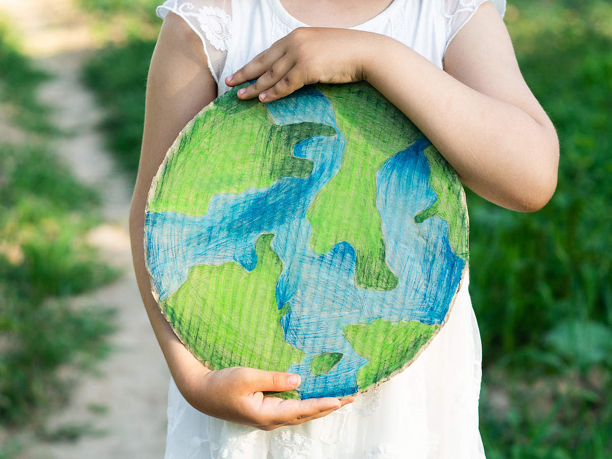 Kind hält die Erde © Anastasiia Stihailo / iStock / Getty Images