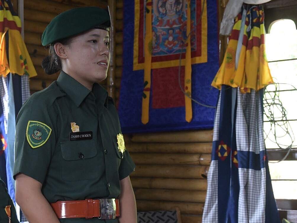 Rangerin in grüner Uniform steht in einem offiziellen Gebäude