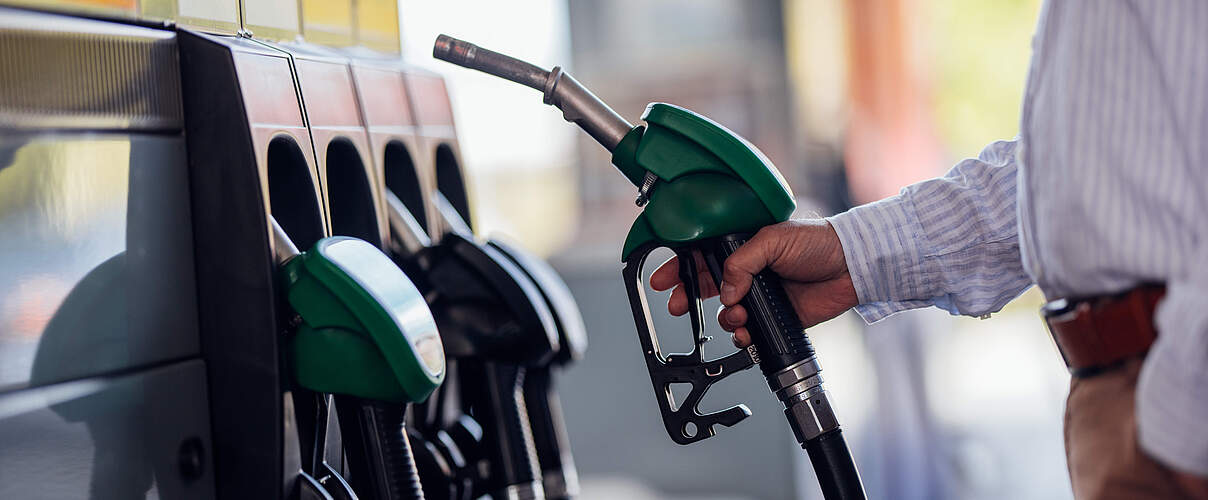 Close-Up of Man Refueling Vehicle at Gas Station Pump