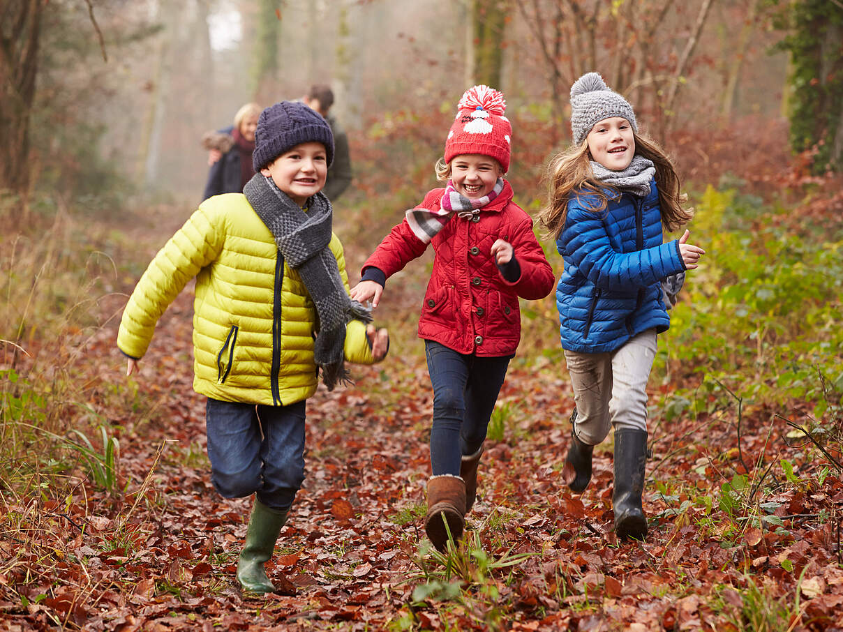 Kinder rennen durch den herbstlichen Wald