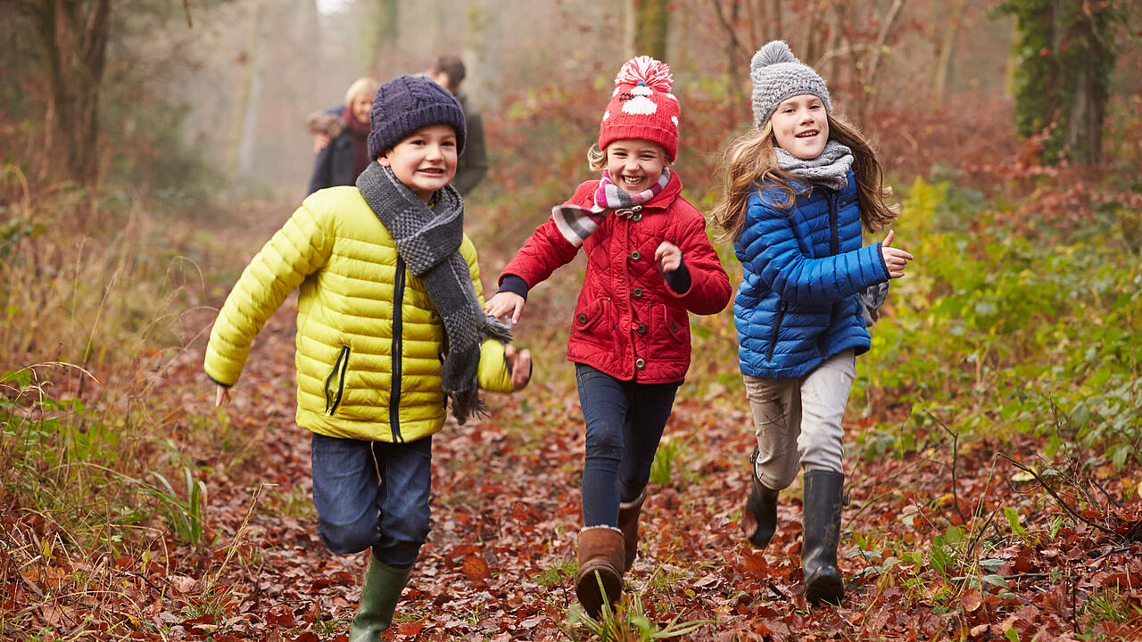 Kinder rennen durch den herbstlichen Wald