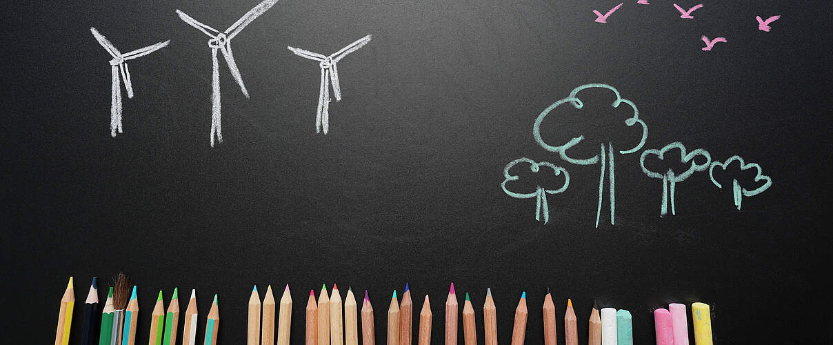 Eine bemalte Tafel und bunte Stifte