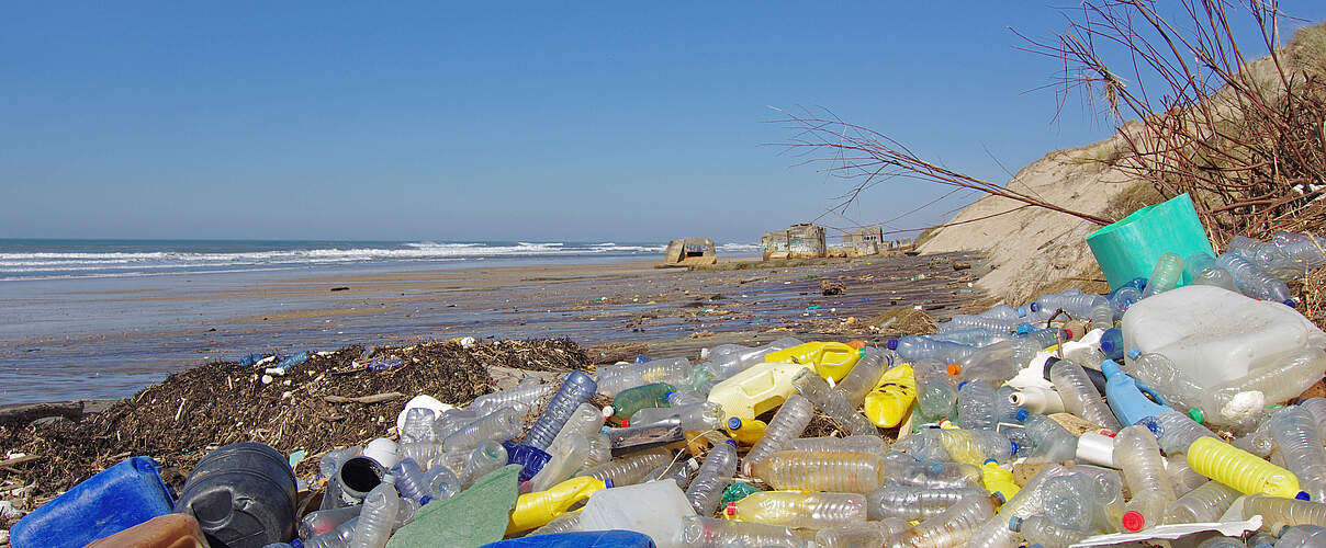 im Vordergrund angeschwemmter Plastikmüll im Hintergrund das Meer.