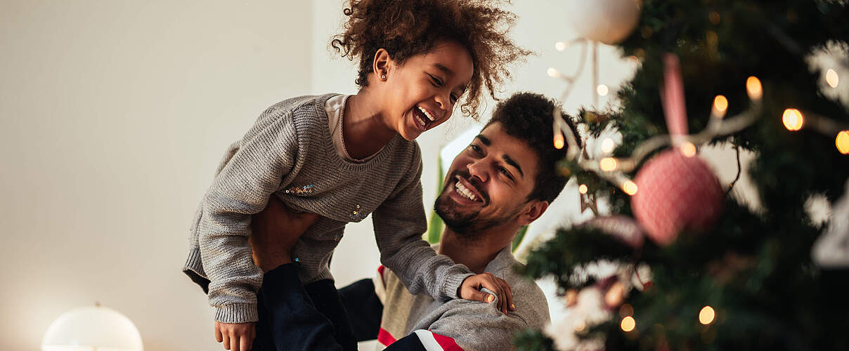 Lachend vor dem Weihnachtsbaum © GettyImages