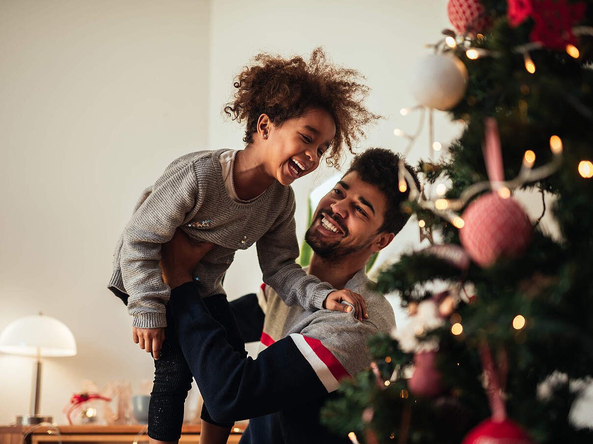 Lachend vor dem Weihnachtsbaum © GettyImages