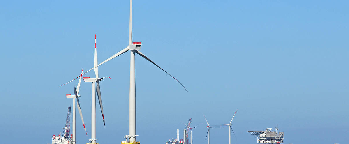 Windräder und Tankstellen im Ozean © Wirestock / iStock / Getty Images