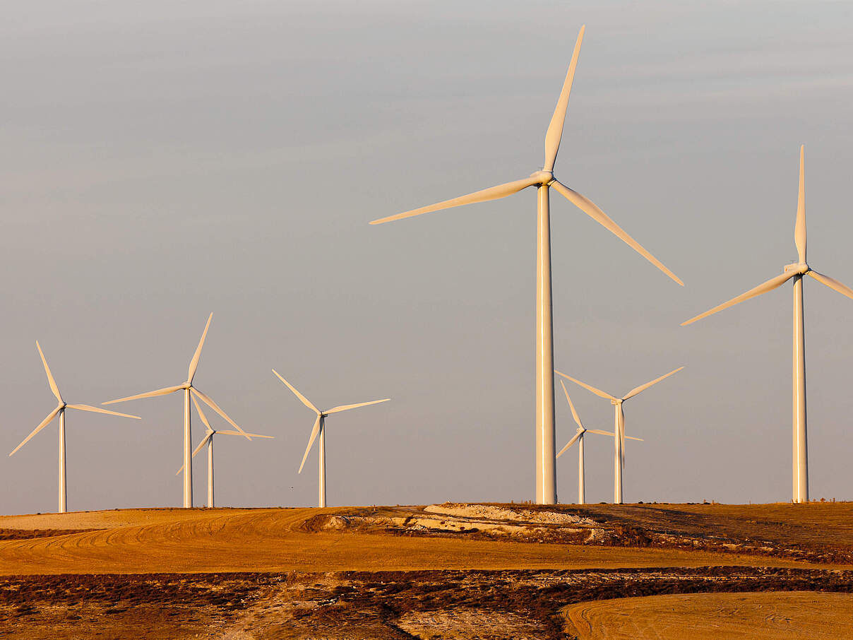 Windkrafträder auf einem Hügel von der Abendsonne in Spanien beschienen