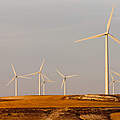 Windkrafträder auf einem Hügel von der Abendsonne in Spanien beschienen