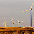Windkrafträder auf einem Hügel von der Abendsonne in Spanien beschienen