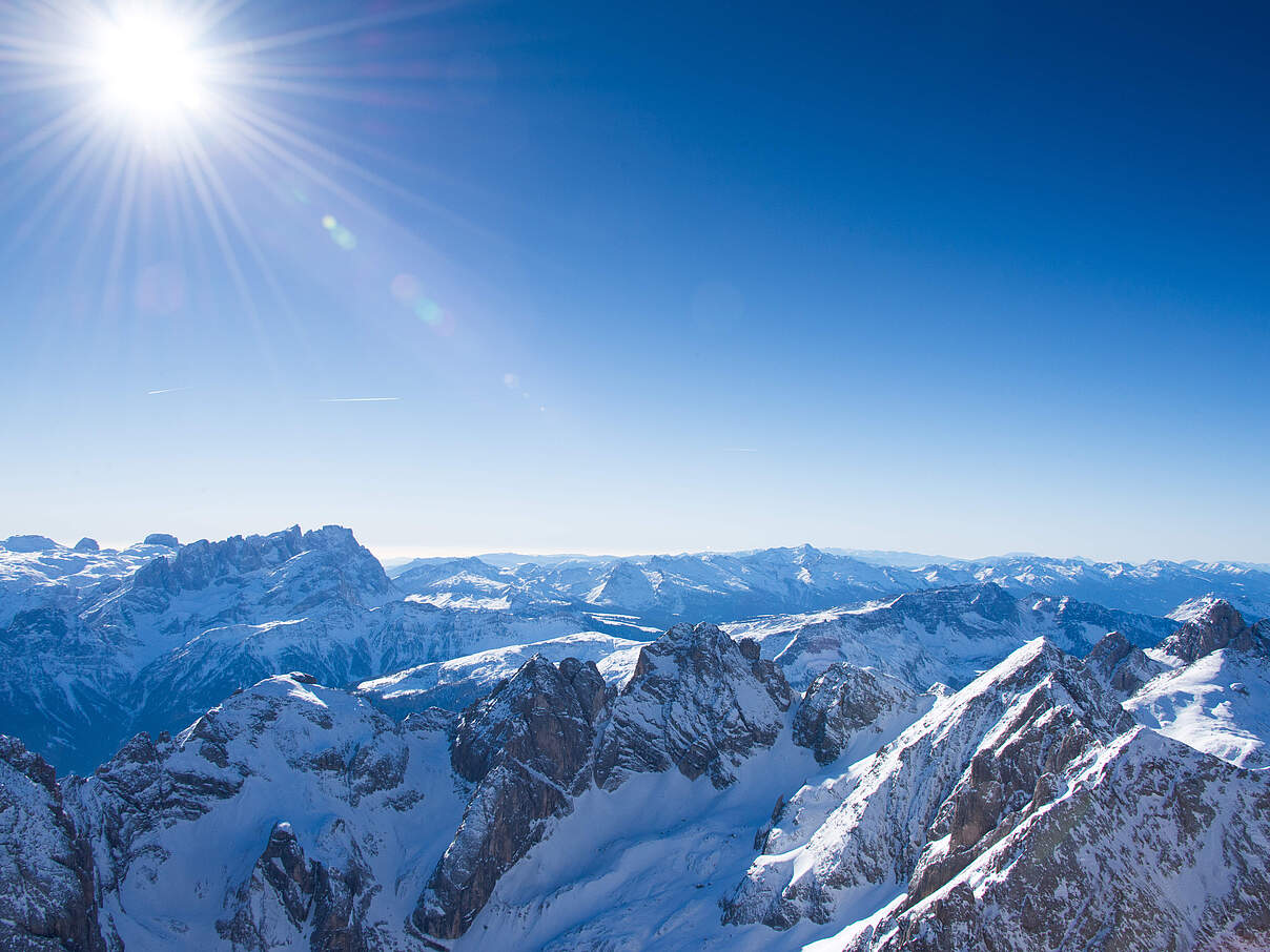 Landschaftsbild der Dolomiten im Winter bei strahlendem Sonnenschein.
