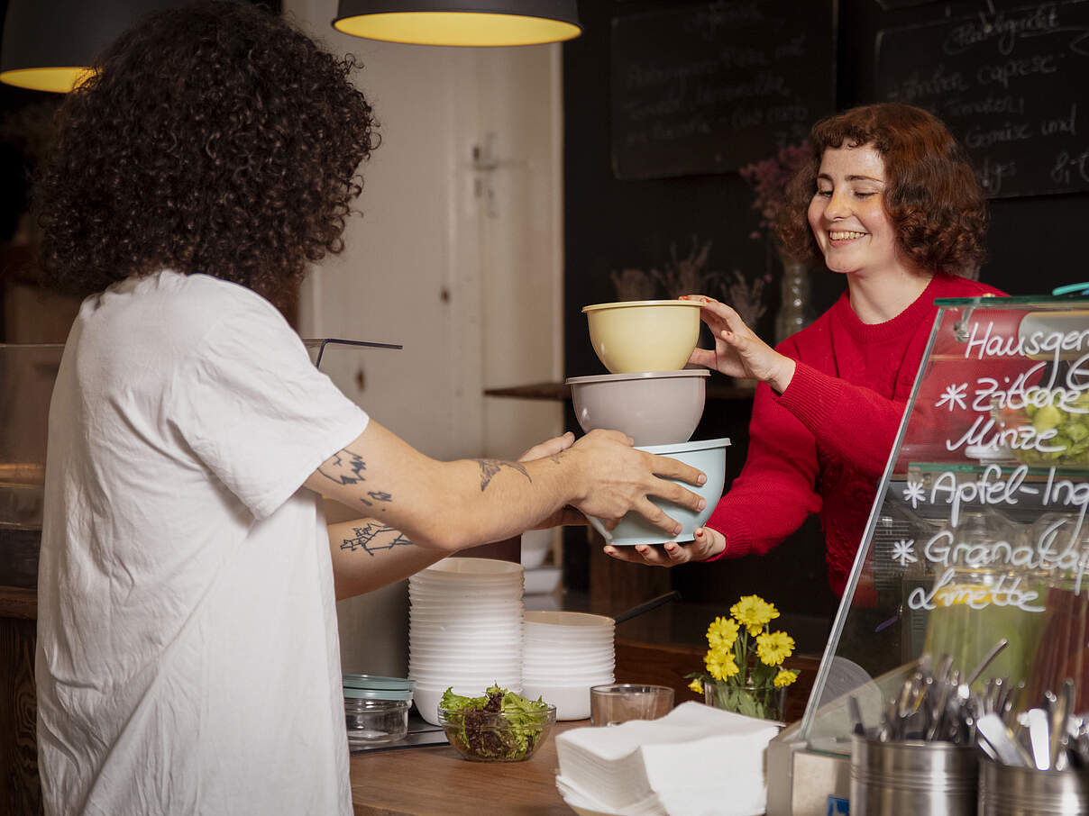 Essen wird in Mehrwegboxen über den Tresen gereicht