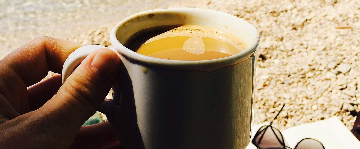 Urlaub mit wiederverwendbarer Tasse am Strand © getty / iStock