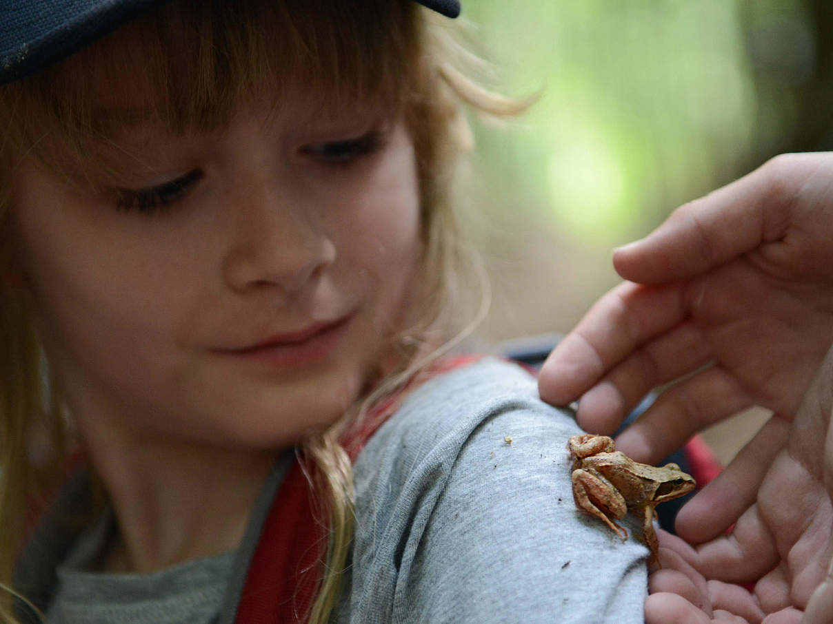 Ein Kind in der Natur mit einem kleinen Frosch auf der Schulter © Peter Jelinek / WWF