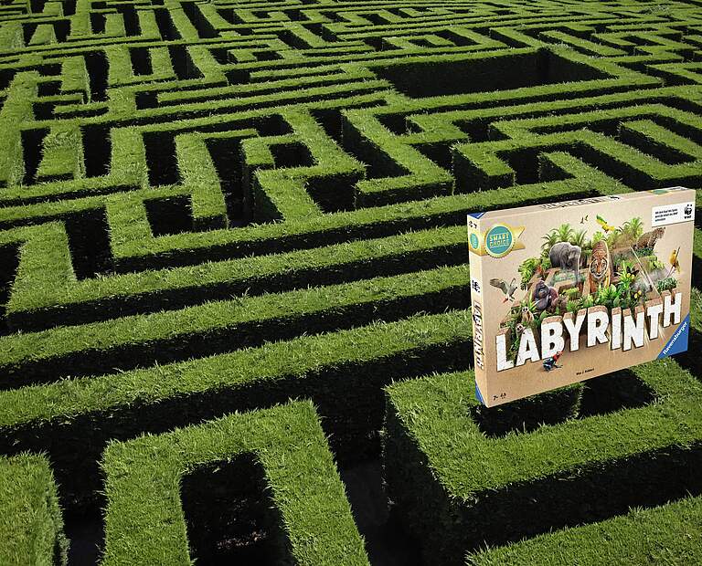 Das Cover des Spiels „Labyrinth“ auf einem Labyrinth aus Hecke © Sergi Nunez / iStock GettyImages / Ravensburger