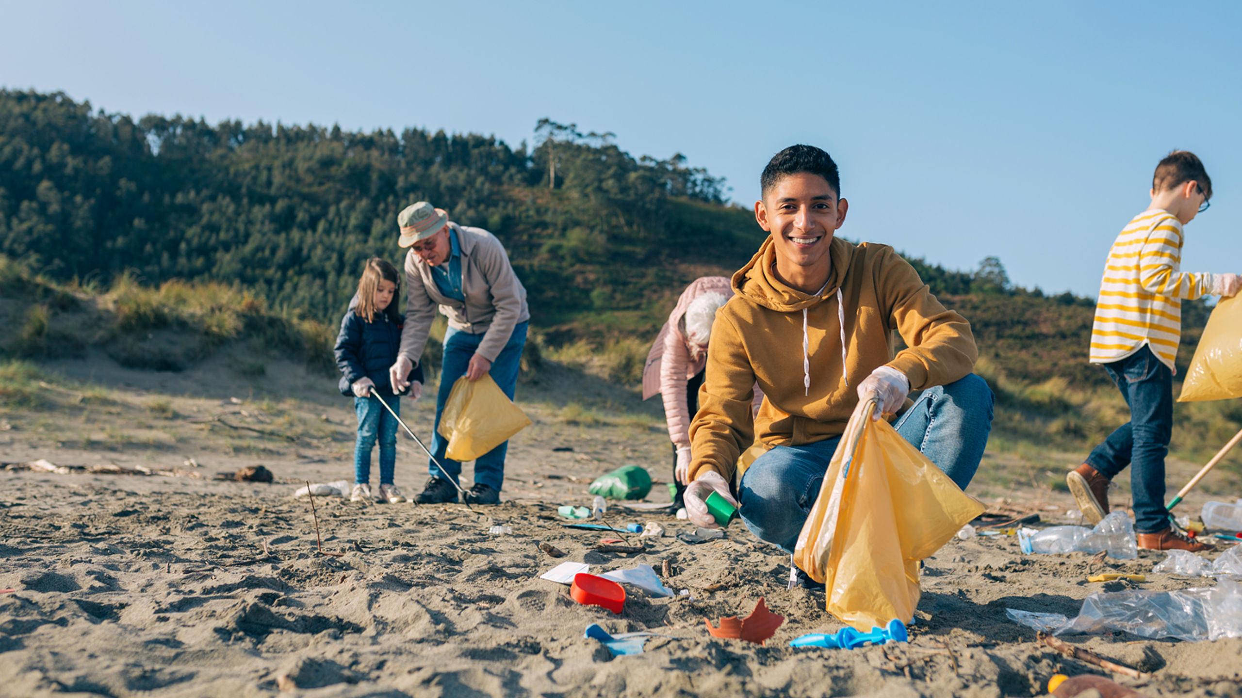 Familie sammelt Müll am Strand © GettyImages